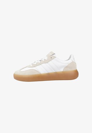 White and beige low-top sneaker with gum rubber sole, lace-up closure, and stitched side stripes on a clean white background.