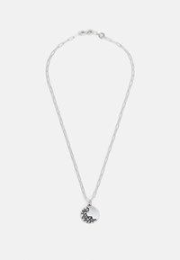 Collier en argent avec un pendentif circulaire présentant un détail texturé et foncé. Design simple et moderne avec une fermeture à fermoir.