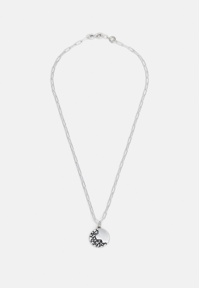 Silver chain necklace featuring a circular pendant with a textured, dark accent detail. Simple, modern design with a clasp closure.