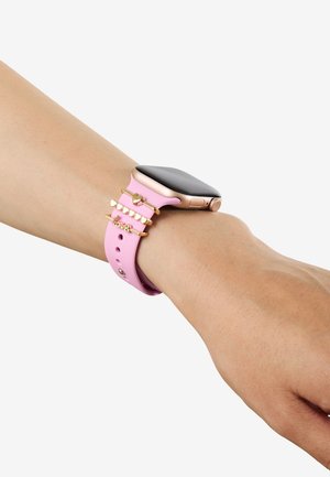 Smartklokke med rosa reim på håndleddet, dekorert med tre gullringer med hjerte- og "love"-charms.