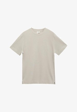 Light beige short-sleeve T-shirt made of ribbed fabric. Classic crewneck design with side slits at the hem. Smooth texture, minimalistic style.