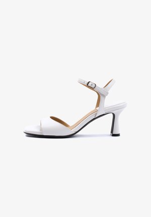 White open-toe high-heeled sandal with ankle strap and buckle, curved heel, and cushioned insole shown from side on white background.