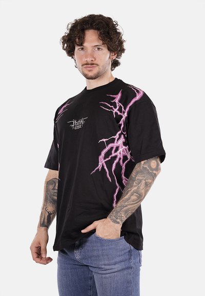 T-shirt in cotone nero con grafiche di fulmini viola sulla parte anteriore, vestibilità ampia, maniche corte e un piccolo logo sul lato sinistro.