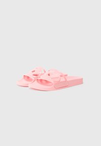 Ružové šľapky z hladkej gumy s charakteristickým dizajnom ramienka v tvare uhlopriečky a plochou podrážkou pre pohodlie.