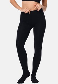Leggings neri a vita alta realizzati in tessuto elastico. Texture liscia, design a lunghezza intera e costruzione senza cuciture per il massimo comfort.