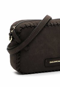 Rudas zomšos crossbody krepšys su siuvinėtais detalėmis, auksiniu užtrauktuku ir logotipu. Yra plonas dirželis ir kompaktiška stačiakampio forma.