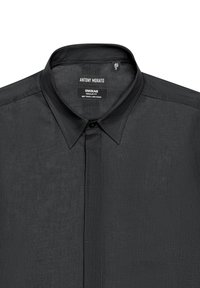Camicia nera button-up realizzata in un morbido misto lino, con colletto classico, vestibilità regolare e una leggera texture. Etichetta visibile all'interno del colletto.