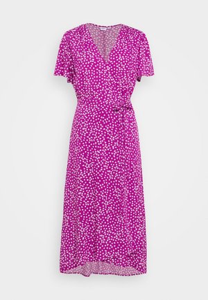 Robe portefeuille violette à manches courtes, motif floral blanc, encolure en V, et ceinture nouée à la taille sur fond uni.