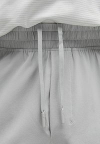 Ljusgrå sweatpants med elastisk midja och dragsnoddar. Mjukt tyg med en slät yta, med en avslappnad passform och enkel detaljer.
