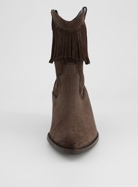 Brauner Wildleder-Stiefel bis zum Knöchel mit Fransenbesatz am oberen Rand und abgerundeter Spitze, von vorne auf weißem Hintergrund abgebildet.