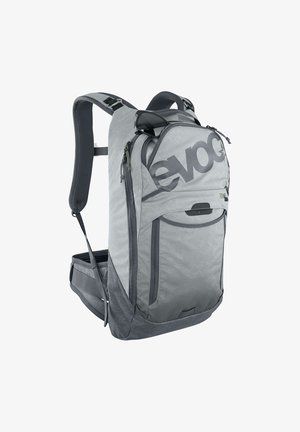 Sac à dos gris de marque Evoc avec bretelles rembourrées, plusieurs compartiments, poche avant en filet et lunettes de soleil accrochées sur la fermeture éclair du haut.