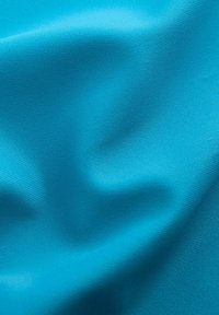 Tessuto in un vibrante turchese, con una superficie liscia e una leggera lucentezza, caratterizzato da morbide pieghe che creano onde delicate e una sottile dimensionalità.
