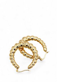 Orecchini a cerchio in oro con superficie rigata e texture, caratterizzati da una forma arrotondata e chiusura con gancio a cerniera. Finitura riflettente e liscia.