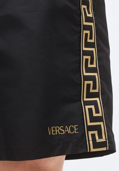 Μαύρο σορτς Versace με χρυσό λογότυπο και σχέδιο ελληνικού κλειδιού στο πλάι, κατασκευασμένο από ομαλό, ελαφρύ ύφασμα.