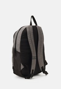 Batoh s šedým a černým textilním designem, polstrovanými popruhy, postranní síťovou kapsou a horním držadlem. Součástí jsou nastavitelné přezky.