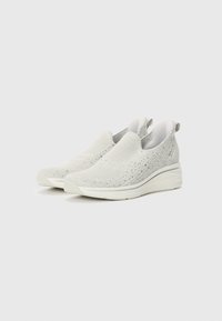 Fehér, slip-on sportcipők texturált kötött felsőrésszel, rugalmas oldalpanellel és vastag fehér talppal. Simma belső bélés és finom fény az anyagon.