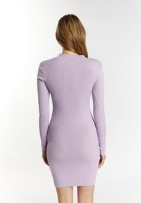 Rippstrick, langärmliges Kleid in hellem Lila mit figurbetonter Silhouette und Rundhalsausschnitt, das eine durchgängige Textur präsentiert.