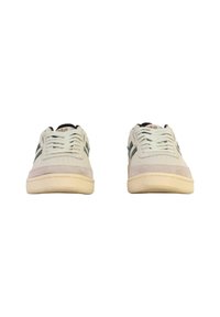 White sneakers with green side stripes and beige soles, viewed from the front against a white background.