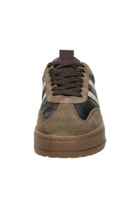 Bruine suède sneakers met geprofileerde zwarte accenten, voorzien van witte strepen, bruine veters en een gladde rubberen Zool. Vierkante tongdetail zichtbaar.