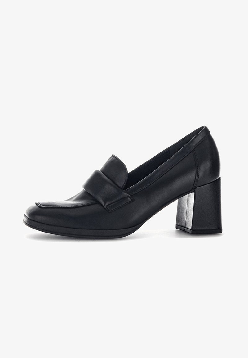 Mocassin femme en cuir noir avec une large bride sur le dessus et un talon bloc sur fond blanc.