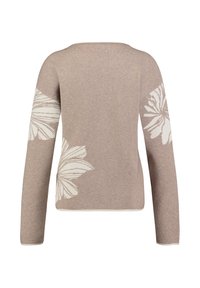 Beżowy sweter z długimi rękawami, zdobiony białymi wzorami kwiatowymi na rękawach, okrągłym dekoltem oraz miękkim, fakturowanym wykończeniem.