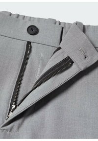 Szare spodnie z zamkiem błyskawicznym, zapięciem na guzik i płaskim przodem. Tkanina jest gładka z delikatną fakturą.