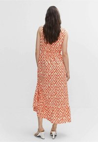 Robe maxi enorange et crème, avec un motif géométrique, sans manches, taille froncée et ourlet à volants. Tissu lisse.