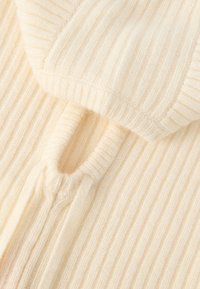 Πλεκτό ύφασμα εκρού με κάθετη ριμπ, με υφασμένη κουκούλα και λεπτομέρεια κορδονιών στον γιακά.