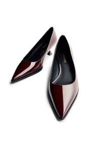 Zapatos de tacón alto de charol burdeos con punta afilada y un pequeño tacón cuadrado. Textura suave con un interior negro. Diseño clásico.