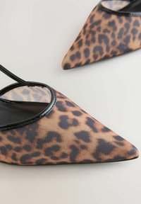 Cipele sa leopard uzorkom, šiljatog vrha, izrađene od mrežastog materijala i ukrašene crnim detaljima. Imaju elegantan dizajn s tankim remenom. Lagan su i teksturiran model.