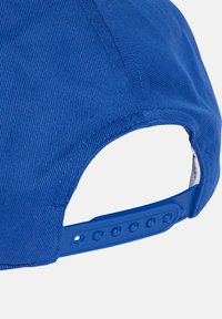Gorra de béisbol azul con tela texturizada, visera curvada y una correa de plástico ajustable con múltiples botones a presión para el ajuste del tamaño.