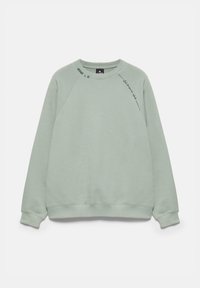 Sweat-shirt vert clair à manches longues avec col rond, petit texte noir près du col et sur l'épaule gauche.