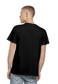 Svart bomull T-skjorte med korte ermer, rund hals, og en enkel bakdesign. Kombinert med lyseblå denimjeans.