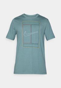 Φωτεινό τυρκουάζ βαμβακερό μπλουζάκι με κοντά μανίκια, που διαθέτει γεωμετρικό σχέδιο από διαγραμμισμένα ορθογώνια και ένα λευκό λογότυπο Nike στο κέντρο.