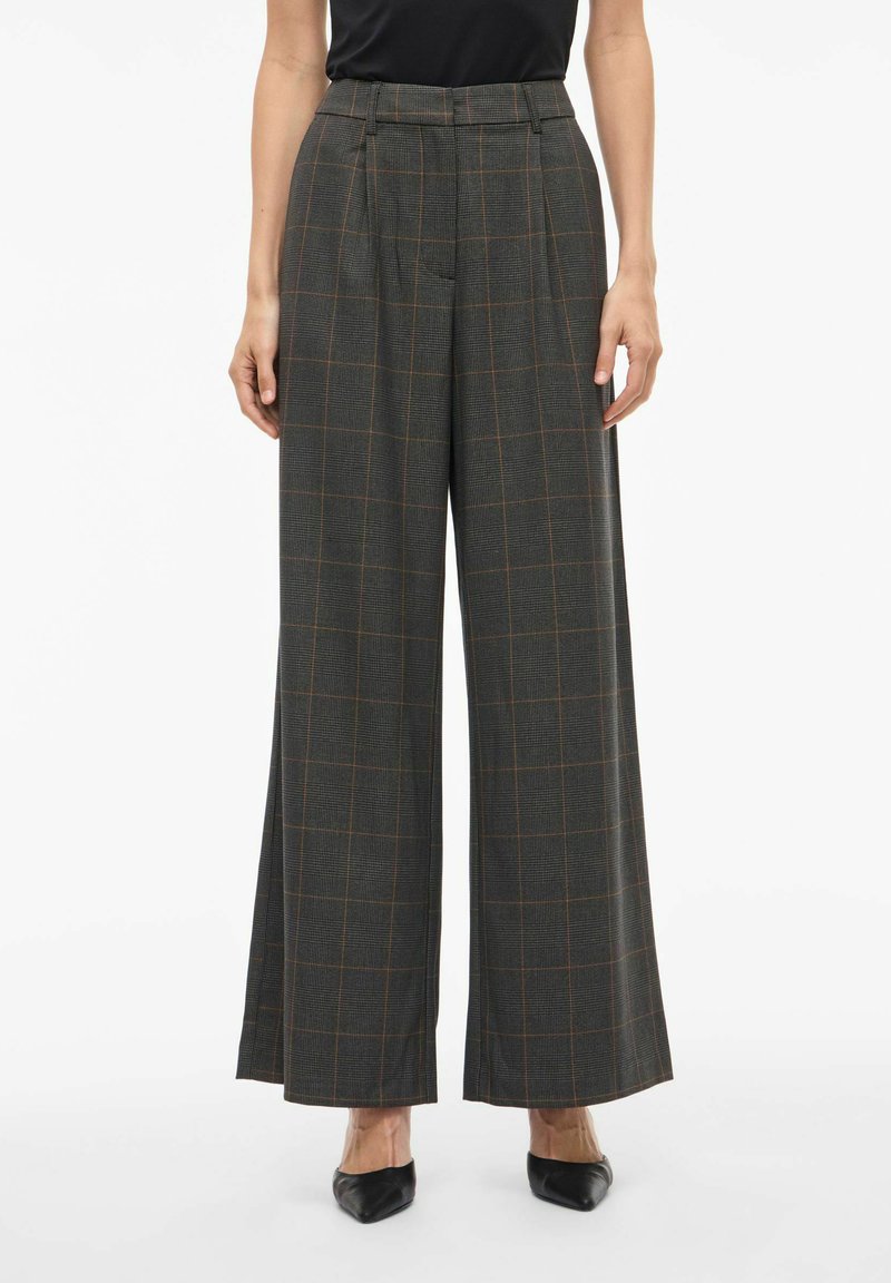 Hlače širokih nogavica u tamnosivoj boji s kariranim uzorkom u narančastim akcentima. Imaju nabore i visoki struk, izrađene su od teksturirane tkanine.