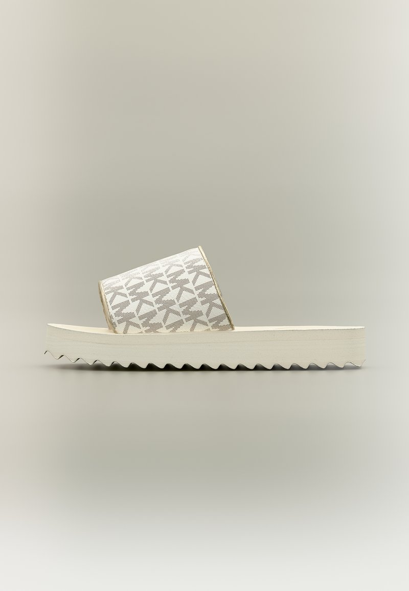 Λευκή πλατφόρμα σαγιονάρα με γκρι φαρδιά λουράκι με μοτίβο και ραβδωτή σόλα σε ουδέτερο φόντο.