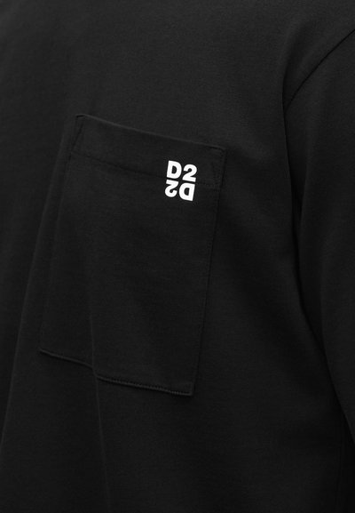 Μαύρο μπλουζάκι με στρογγυλή λαιμόκοψη, που διαθέτει τσέπη στο στήθος. Η τσέπη έχει λευκό λογότυπο «D2». Το ύφασμα φαίνεται μαλακό και λείο.