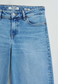 Light blue low-rise Salsa Jeans in wide fit with front button, zipper, and pockets on a plain background.