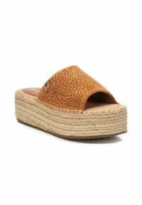 Sandal de ante marrón, tipo slide, con diseño perforado, suela de plataforma envuelta en yute y plantilla de cuero marrón. Presenta una puntera abierta.