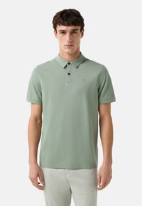 Lys grøn polo skjorte lavet af bomuld, med en klassisk krave, tre-knaps placket og et lille broderet logo på brystet.