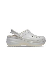 Silberne Glitzer-Clogs mit einem flauschigen Futter, offener Rückseite, Belüftungsöffnungen und einem strukturierten Riemen. Leicht erhöhte Gummisohle für guten Halt.