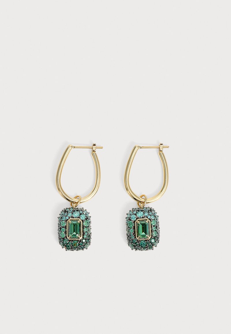 Boucles d'oreilles créoles en or avec des pierres centrales vertes taillées en émeraude entourées de petites pierres précieuses vertes sur fond blanc.