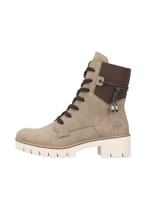 Bottines en suede beige avec un dessus en maille texturée marron, des lacets marron et une semelle en caoutchouc blanche épaisse avec des rainures pour l'adhérence.