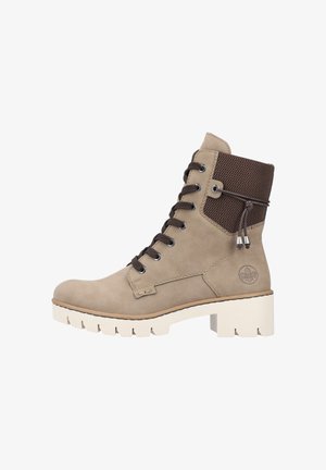Bottines en suede beige avec un dessus en maille texturée marron, des lacets marron et une semelle en caoutchouc blanche épaisse avec des rainures pour l'adhérence.
