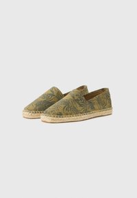 Espadrile cu un model floral verde, parte superioară din pânză și talpă din iută naturală. Design distinctiv tip slip-on cu vârf rotunjit.