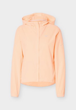 Veste à capuche orange clair avec fermeture éclair intégrale à l'avant, poignets élastiques et détails réfléchissants subtils sur les manches et la poitrine.