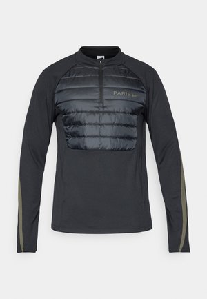 Zwarte langemouwen top met een kwart ritssluiting, voorzien van een gewatteerd voorpand en olijfgroene accenten op de mouwen. "PARIS" logo in lichtgrijs.