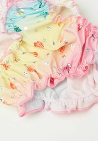 Maillots de bain multicolores avec un dégradé du bleu au rose, ornés de motifs de coquillages et de accents en étoile argentée, terminés par des bords festonnés.