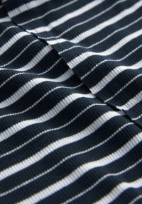 Kankaan tummansininen ja valkoinen raitakuvio, jossa on ribbitekstuuri, sisältäen vuorotellen leveitä ja kapeita raitoja sileästä ja joustavasta materiaalista.