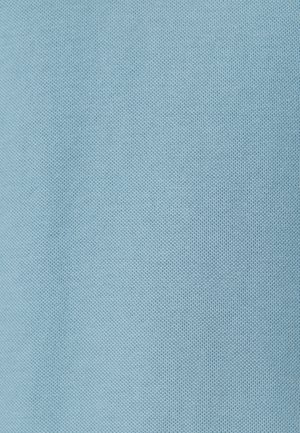 Lichtblauw textiel met een fijn geweven patroon en subtiele verhoogde stippen, in close-up detail weergegeven.